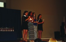 Sophomore Emma Frati, juniors Morgan Greaton and Paola Rodriguez, and senior Isabella Uccelli hold symbolic candles as they are inducted into the Italian Honor Society. Photo by Katherine Cohen.